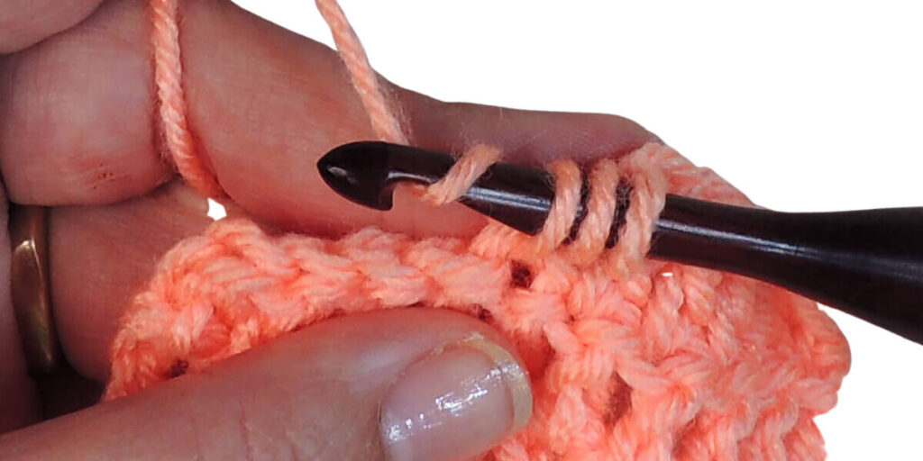 Photo showing step just explained for making a double crochet.