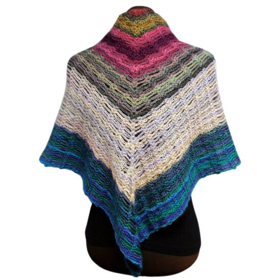Back of a brown dress form in a black tank top with a triangular crochet shawl with stripes of varying sizes in shades of cream, pink, green, and blue. The shawl point is in the back and the sides are draped over the shoulders.