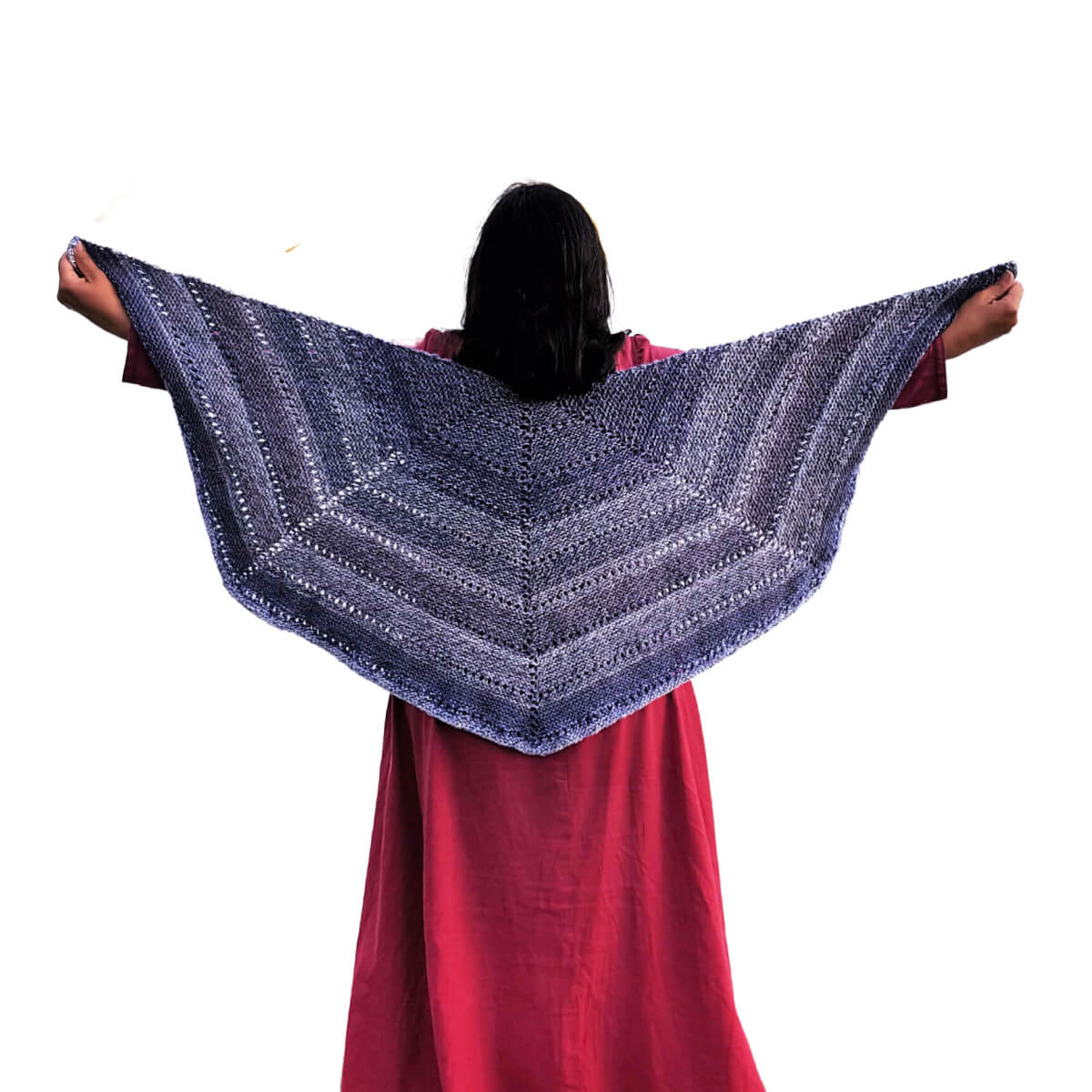 Back view of a woman in a red dress and a knit shawl made of 4 triangles connected to make 4/6 of a hexagon. The shawl is knit in garter stitch with a row of eyelets every few inches. The woman's arms are outstretched to the sides, holding the shawl so it can be clearly seen.