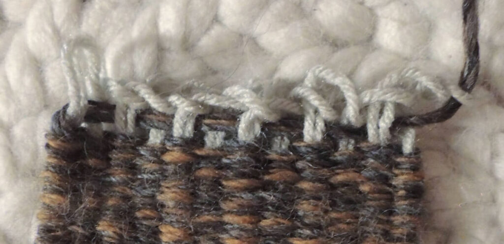 Image of the end of the weaving showing the yarn tail pulled through the last loop.