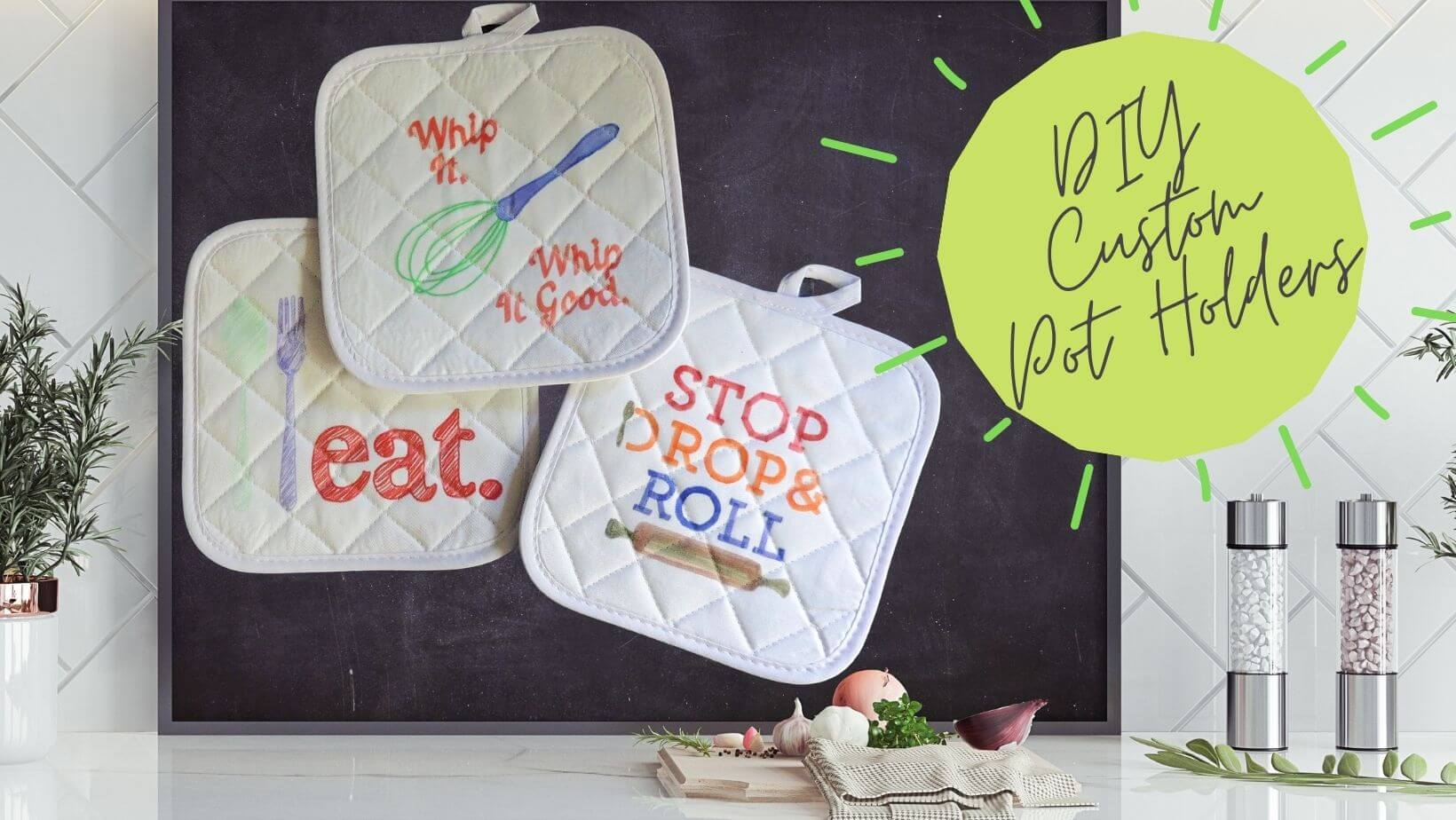 Rectangular image of a kitchen counter with a chalkboard backsplash. On the chalkboard is an image of 3 pot holders, one with a drawing of a whisk and "whip it, whip it good", one with a drawing of a spoon and fork and "eat.", and one with "stop, drop & roll" and a drawing of a rolling pin. To the right of the chalkboard is a lime green circle with text "DIY custom pot holders."