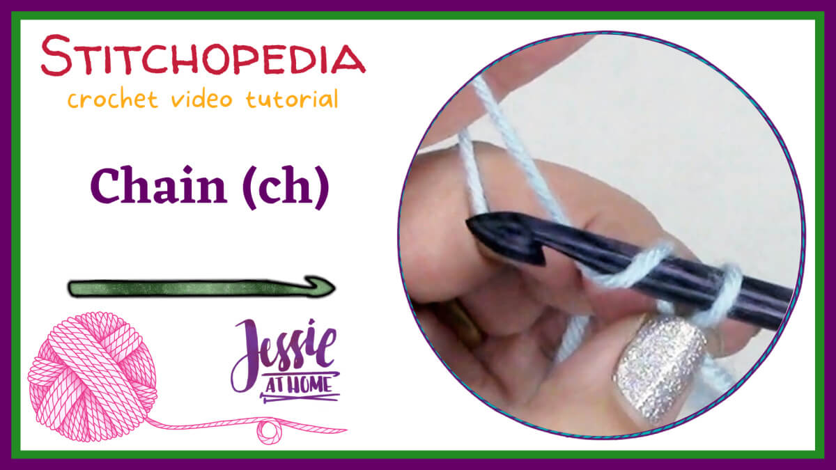 A white horizontal rectangle with a green border then a purple border. On the right half is a circular photo of a white hand making a crochet chain stitch. On the top left is text which reads "Stitchopedia crochet video tutorial" an "chain (ch)". On the bottom left are graphics of a green crochet hook and a pink ball of yarn and the "Jessie At Home" logo.