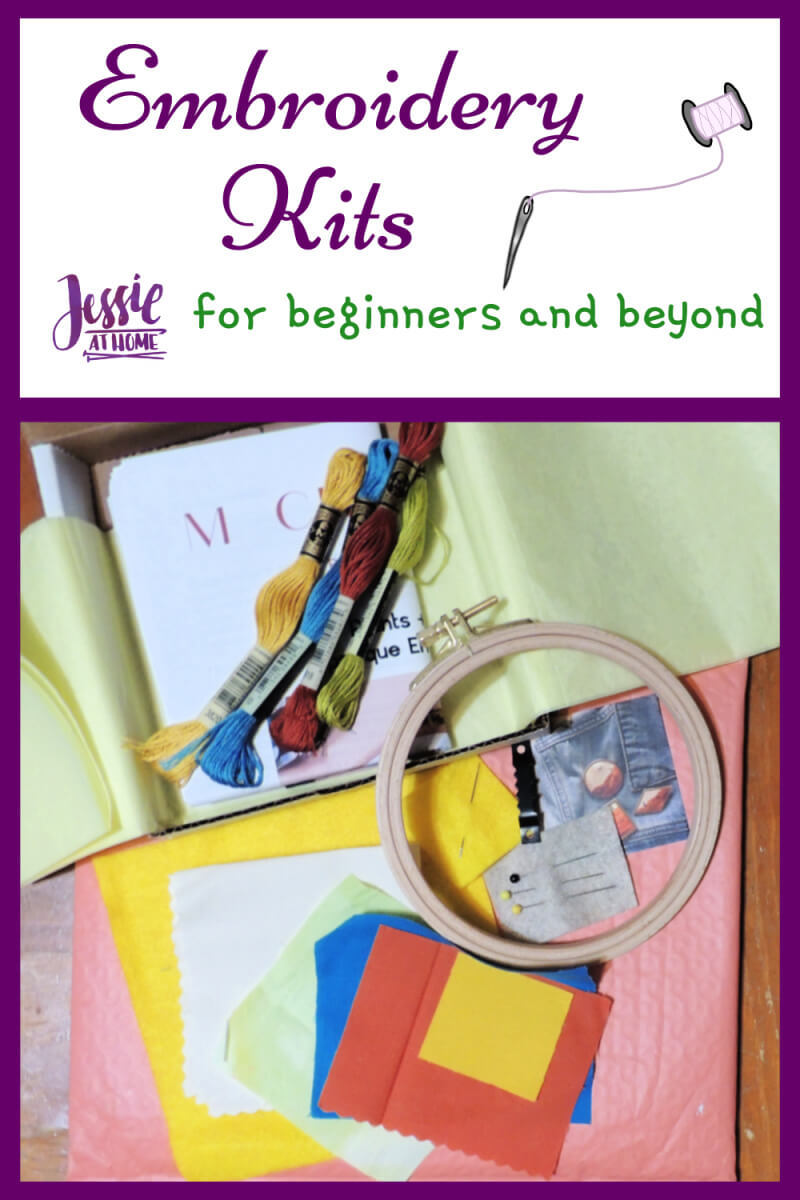 A white vertical rectangle with purple boarder. On the top third is text "Embroidery Kits", "for beginners and beyond", and "Jessie At Home." The bottom two thirds is a photo of a coral shipping padded envelope on top of a wood table. On top of that is an open thing white box with yellow tissue paper lining opened up. On top of all of that are various pieces of fabric, embroidery floss, pins and needles, an embroidery hoop, a picture hanger, and instructions; all from the box.