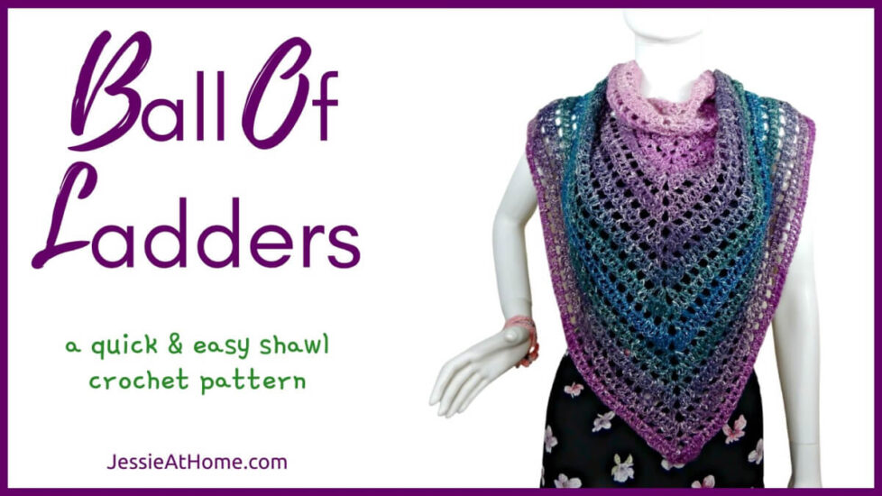 White horizontal rectangle with purple boarder. On the left is text "Ball of Ladders", "a quick and easy shawl crochet pattern" and "Jessie At Home dot com." On the right is a photo of a white mannequin in a black tank top, black skirt with light flowers and a triangular crochet shawl that changes colors through pink, purple, green, and blue. Shawl alternates between rows of solid stitches and rows of net stitches. Shawl is on with the point in front and the sides gathered at the shoulders.