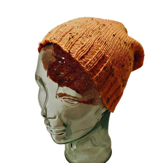 Photo of front side of glass mannequin head in an orange tweed knit stocking hat with rib stitches at bottom and stockinette stitches for rest of hat.