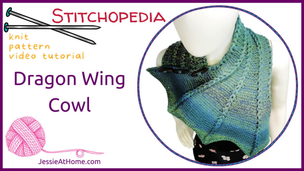White horizontal rectangle with purple boarder. On the left is text text "Stitchopedia knit pattern video tutorial", "Dragon Wing Cowl" and "Jessie At Home dot com" and graphics of knitting needles and pink yarn. On the right is an image of a white mannequin in a blue and green variegated knit cowl that's thin on one end then wraps around the neck and buttons to the other end which has flared out with 5 points. There are columns of raised large stitches from the short end to the tips.