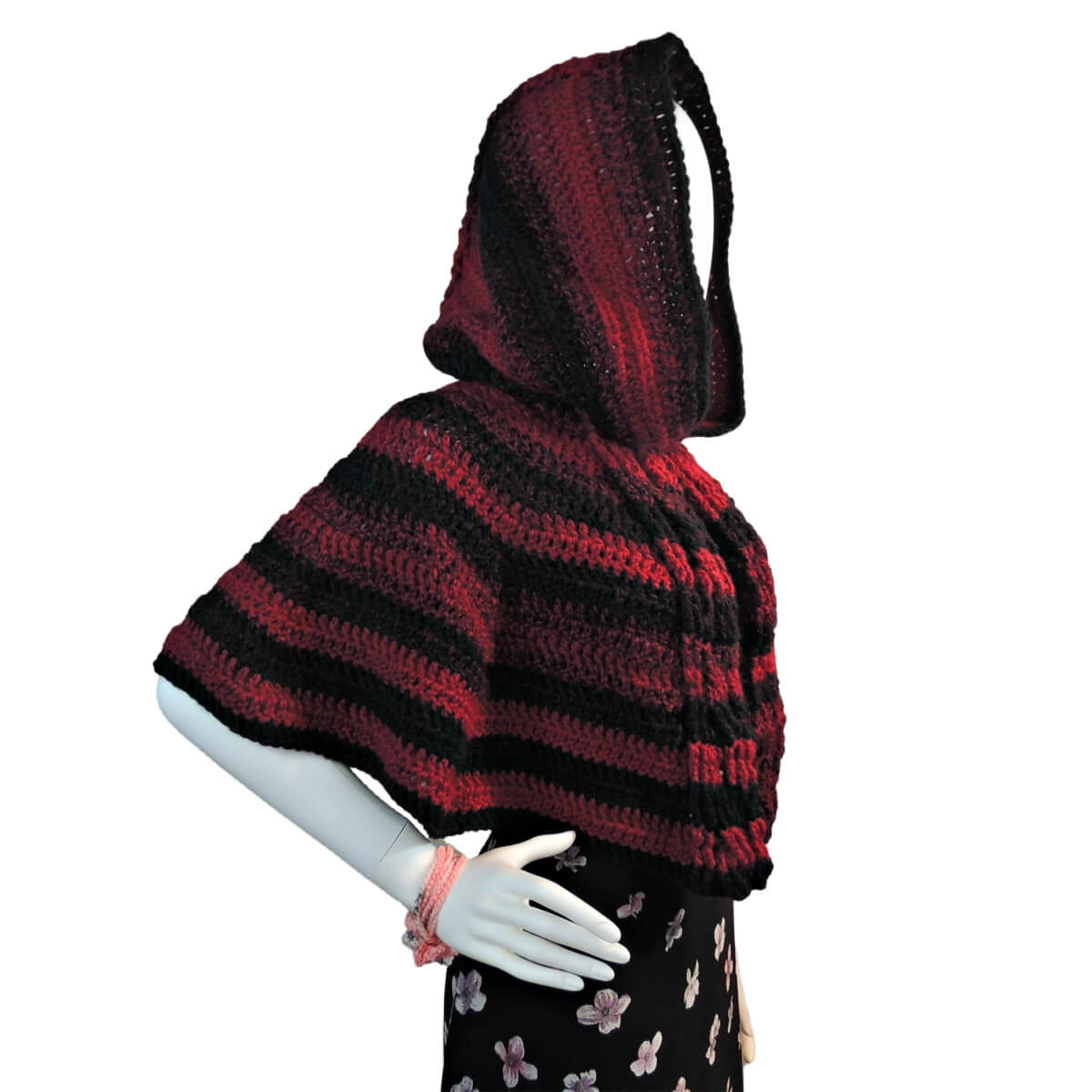 Back of a white mannequin in a black tank top, black skirt, and a triangular crochet shawl that changes colors through pink, purple, green, and blue. Shawl alternates between rows of solid stitches and rows of net or eyehole stitches. The shawl is laying flat across the back so the stitching can clearly be seen.