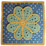 A crochet granny square with a single crochet border, overlayed on the square is a large flower with 8 petals each outlined in slip stitches. The square is blue with a yellow border and the flower is green with a yellow outline.